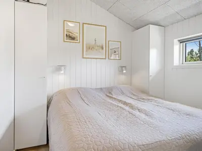 a white bedroom with a bed and a window at Holiday Home Ema - 1-9km from the sea by Interhome in Saltum