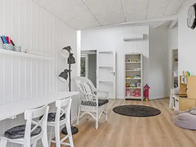 a white dining room with a table and chairs at Holiday Home Ema - 1-9km from the sea by Interhome in Saltum