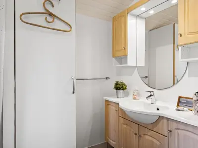 a bathroom with a sink and a mirror at Holiday Home Hermand - 3-5km from the sea by Interhome in Brovst