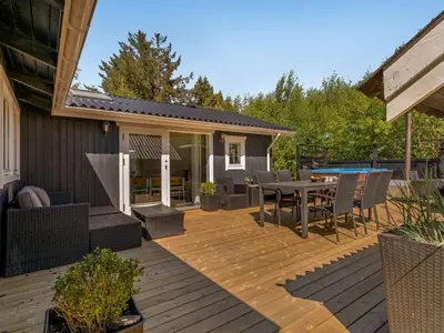 a patio with a table and chairs on a deck at Holiday Home Hermand - 3-5km from the sea by Interhome in Brovst
