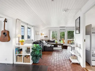 a living room with a couch and a guitar at Holiday Home Hermand - 3-5km from the sea by Interhome in Brovst