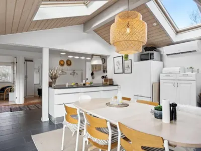 a kitchen and dining room with a table and chairs at Holiday Home Hermand - 3-5km from the sea by Interhome in Brovst