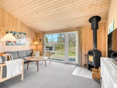a living room with a couch and a wood stove at Holiday Home Elisenda - 1km from the sea by Interhome in Torsted