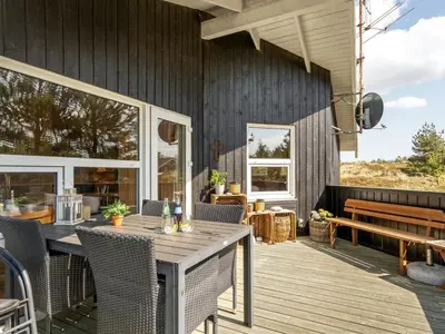 an outdoor deck with a table and chairs at Holiday Home Elisenda - 1km from the sea by Interhome in Torsted