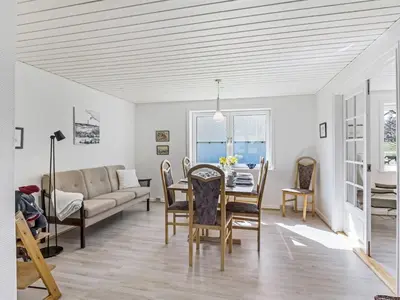 a living room with a table and a couch at Holiday Home Kerrin - 1km from the sea by Interhome in Hanstholm