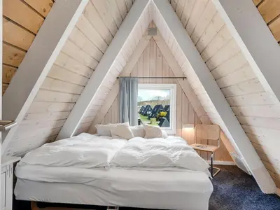a bedroom with a white bed in the attic at Holiday Home Erly - 18km to the fjord by Interhome in Farsø
