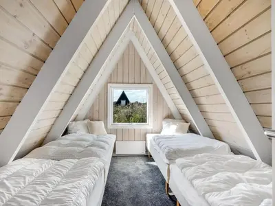a attic room with four beds and a window at Holiday Home Erly - 18km to the fjord by Interhome in Farsø