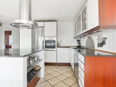 a kitchen with white cabinets and a counter top at Holiday Home Lilie - 350m from the sea by Interhome in Saltum