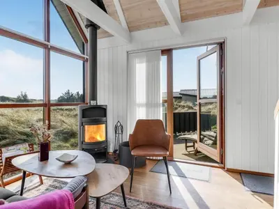a living room with a fireplace and a table at Holiday Home Lilie - 350m from the sea by Interhome in Saltum