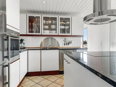a kitchen with white cabinets and a glass counter top at Holiday Home Lilie - 350m from the sea by Interhome in Saltum