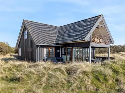 a black house on top of a hill at Holiday Home Lilie - 350m from the sea by Interhome in Saltum