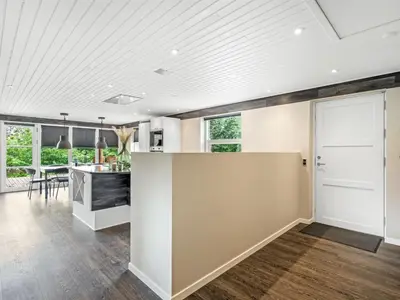 an open kitchen and dining room with white walls and wood floors at Holiday Home Skip - 300m to the fjord by Interhome in Højslev