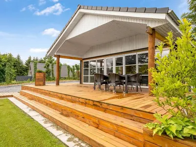 a wooden deck with a table and chairs on it at Holiday Home Skip - 300m to the fjord by Interhome in Højslev