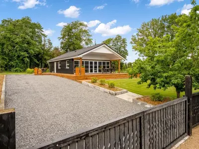 a house with a fence and a gravel driveway at Holiday Home Skip - 300m to the fjord by Interhome in Højslev