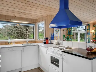 a kitchen with white cabinets and a blue ceiling at Holiday Home Sella - 200m from the sea by Interhome in Torsted