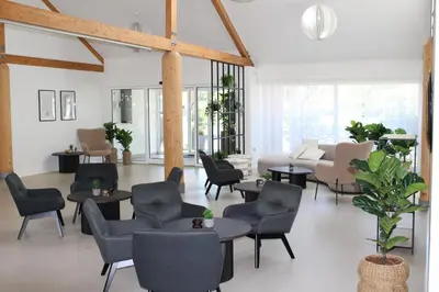 a living room with chairs and tables and a couch at Hotel Traneparken in Nykøbing Mors
