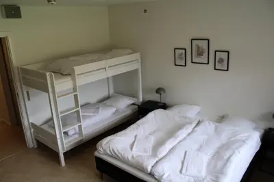 two white bunk beds in a room with a ladder at Hotel Traneparken in Nykøbing Mors