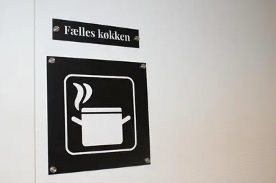 a sign with a coffee cup on a wall at Hotel Traneparken in Nykøbing Mors