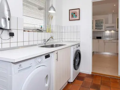 a kitchen with a washing machine and a sink at 4 star holiday home in Blokhus-By Traum in Blokhus