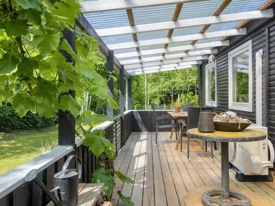 an outdoor deck with a pergola and a table at 5 person holiday home in Thyholm-By Traum in Thyholm