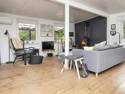 a living room with a couch and a fireplace at 5 person holiday home in Thyholm-By Traum in Thyholm