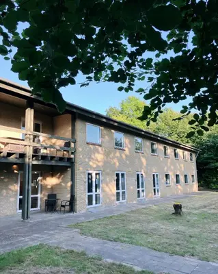 a large brick building with a dog in front of it at Skovly in Viborg