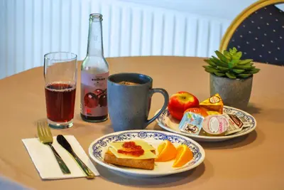 a table with two plates of food and a bottle of wine at Skovly in Viborg