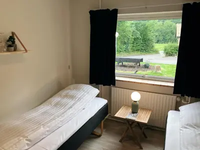a small bedroom with a bed and a window at Skovly in Viborg