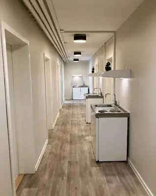 a hallway of a kitchen with white appliances at Skovly in Viborg