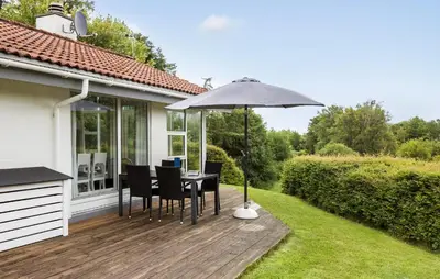 a table with an umbrella on a wooden deck at 3 Bedroom Gorgeous Home In Fur in Furland