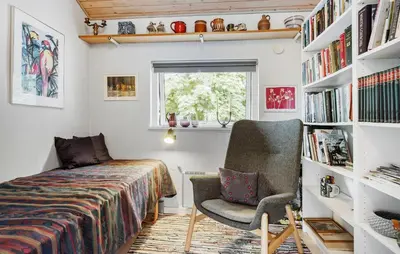 a bedroom with a bed and a chair and bookshelves at 3 Bedroom Gorgeous Home In Fur in Furland