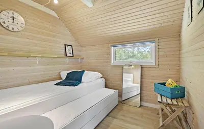 a small bedroom with a bed and a clock at 2 Bedroom Beautiful Home In Farsø in Farsø