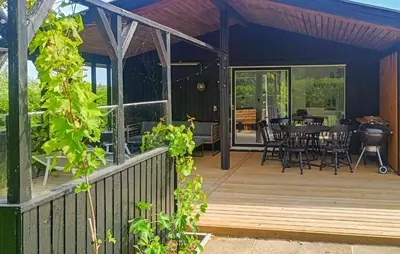 a house with a deck with a table and chairs at 3 Bedroom Cozy Home In Vinderup in Vinderup