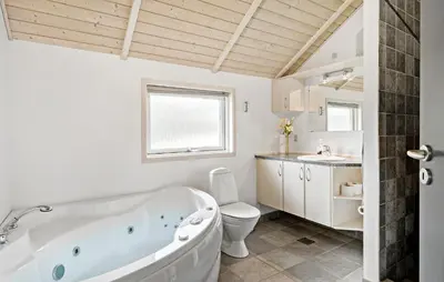 a bathroom with a tub and a toilet and a sink at 3 Bedroom Cozy Home In Højslev in Højslev
