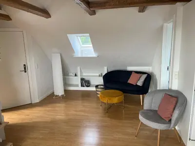 a living room with a blue chair and a table at Thisted Centrum in Thisted