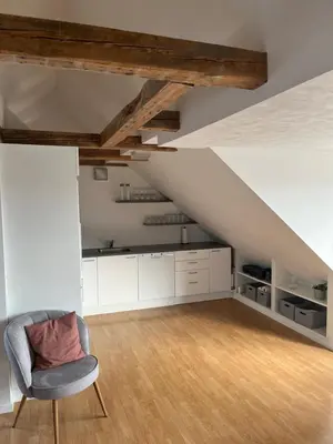 an attic room with a chair and a staircase at Thisted Centrum in Thisted