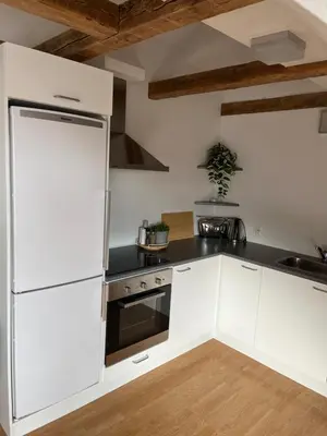 a kitchen with white cabinets and a refrigerator at Thisted Centrum in Thisted