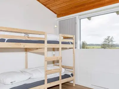 a bunk bed room with two bunk beds and a window at 12 person holiday park home in Hanstholm in Hanstholm