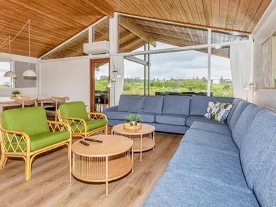 a living room with a blue couch and chairs at 12 person holiday park home in Hanstholm in Hanstholm