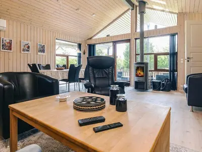 a living room with a table and a fireplace at 4 star holiday home in Øster Assels-By Traum in Øster Assels