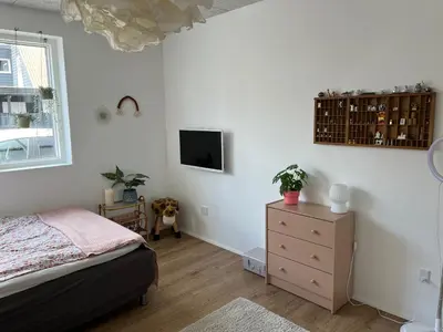 a bedroom with a bed and a tv on the wall at Hus tæt ved havn og strand in Thyborøn