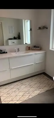 a white bathroom with a sink and a mirror at Hus tæt ved havn og strand in Thyborøn