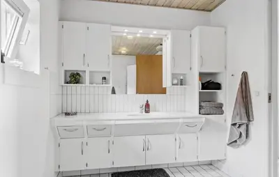 a white bathroom with a sink and a mirror at 4 Bedroom Beach Front Home In Thyholm in Thyholm