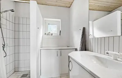 a white bathroom with a sink and a shower at 4 Bedroom Beach Front Home In Thyholm in Thyholm