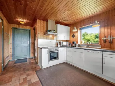 a kitchen with white cabinets and a wooden ceiling at Holiday Home Arlin - 380m to the fjord by Interhome in Vemb
