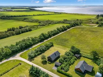 an aerial view of a farm with a house and the ocean at Holiday Home Arlin - 380m to the fjord by Interhome in Vemb
