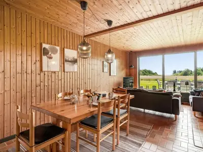 a dining room with a wooden table and chairs at Holiday Home Arlin - 380m to the fjord by Interhome in Vemb