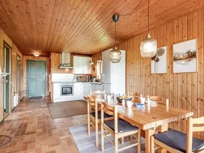 a kitchen and dining room with a wooden table and chairs at Holiday Home Arlin - 380m to the fjord by Interhome in Vemb