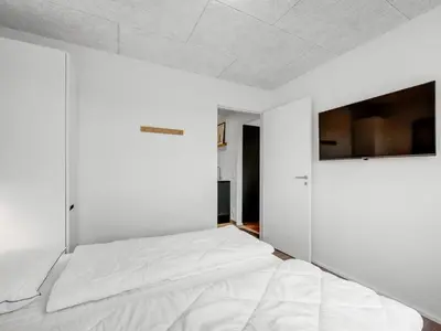 a bedroom with white walls and a large bed at Holiday Home Dreng - 300m from the sea by Interhome in Harboør
