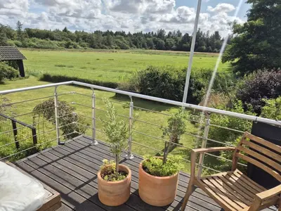 a deck with two potted plants and a bench at Holiday Home Cillvur - 8km from the sea by Interhome in Thisted